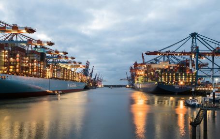 maersk ports in the evening with bright lights shinning over the sea