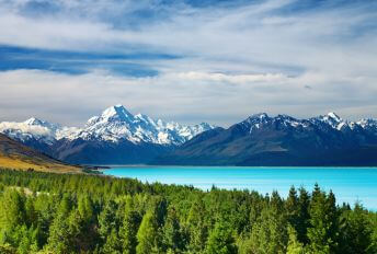 A scenic image of New Zealand's mountainous range. A breath-taking view of snow-capped peaks and luscious green valleys,