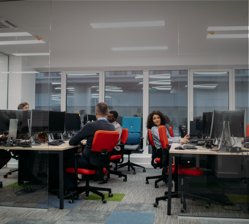 Employees in an open plan office, representing the workforce Pickfords Relocation supports with bespoke relocation programmes tailored to their needs.