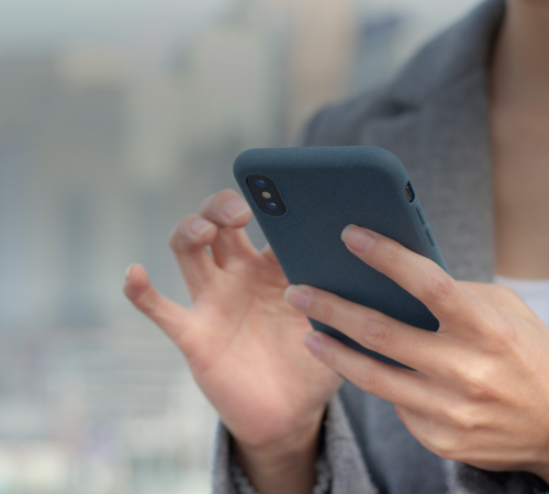 Person using a smartphone, representing accessible relocation technology designed to support assignees during their move.